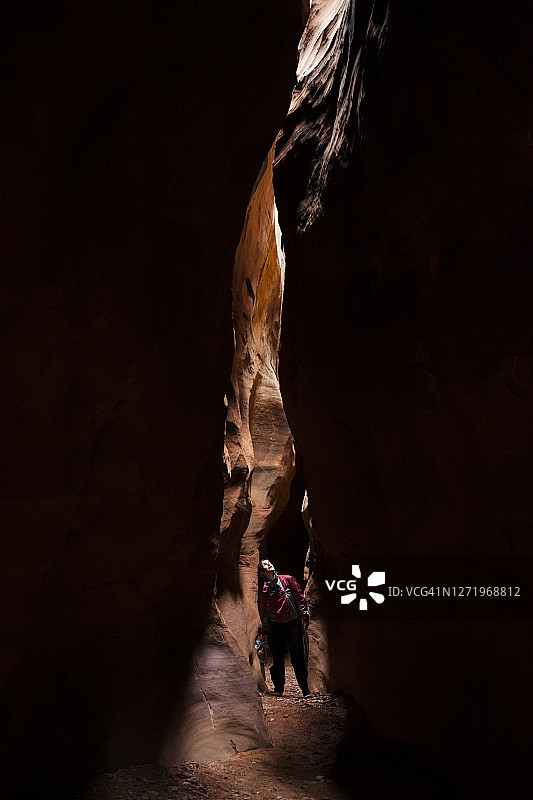女人在美国犹他州埃斯卡兰特河附近探索砂岩峡谷图片素材