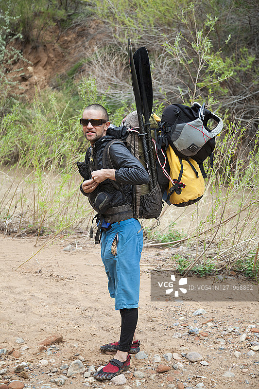 背着漂流装备的男人在犹他州埃斯卡兰特河上图片素材