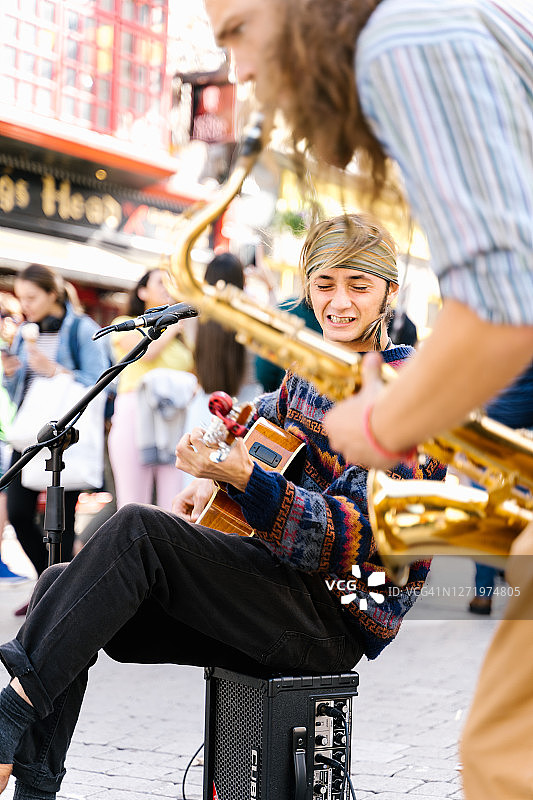 街头艺人：唱歌的男人和萨克斯演奏者图片素材