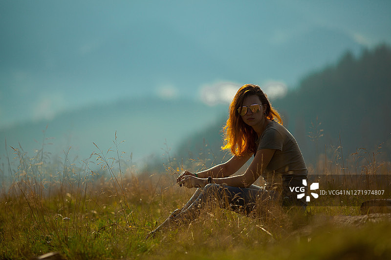 女孩坐在喀尔巴阡山脉的草地上图片素材