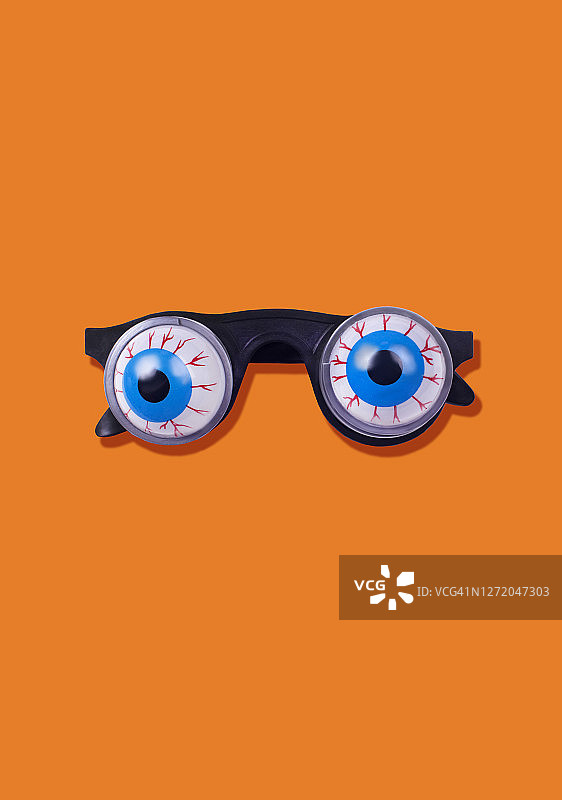 橙色背景上的弹簧眼睛滑稽眼镜图片素材