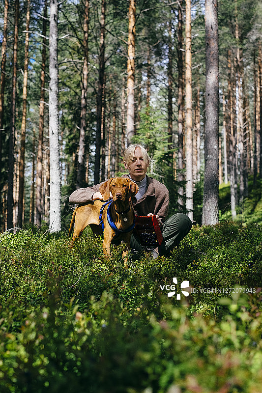 年轻女人在森林里与维兹拉犬共度时光图片素材