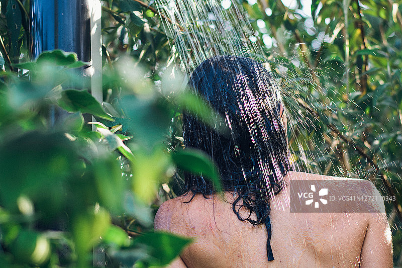 年轻女人在花园里淋浴图片素材