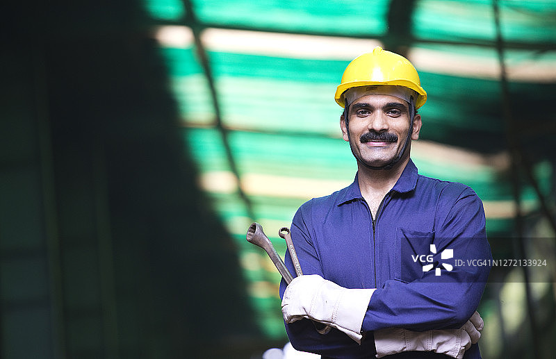 工厂里身穿防护服的自信产业工人图片素材