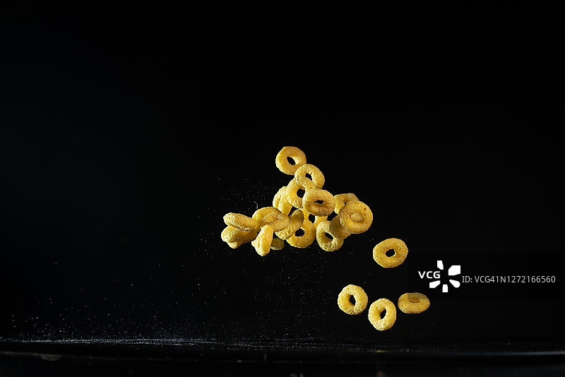 高速同步拍摄的玉米圈早餐在空中飞行图片素材