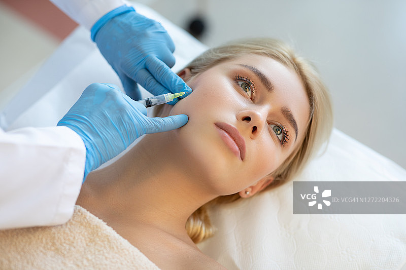 年轻女人在整容手术中脸部注射图片素材