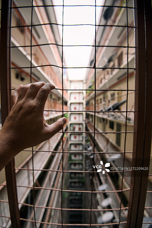 手扶着栅栏看公房图片素材