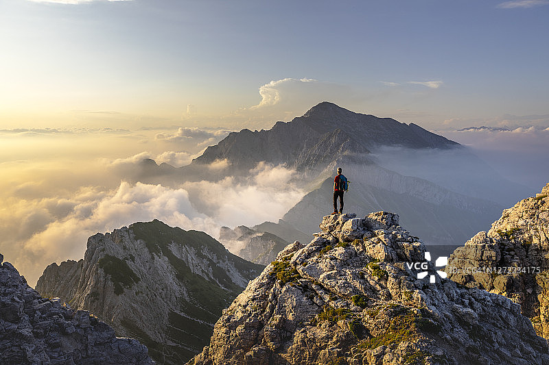 徒步者在意大利贝加莫阿尔卑斯山峰顶欣赏美景图片素材