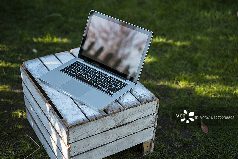 后院木箱上的笔记本电脑高角度视图图片素材