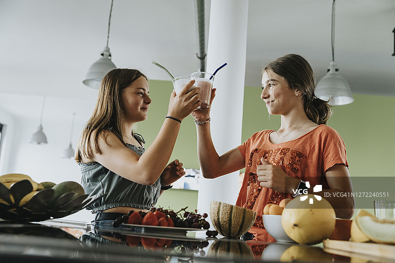少女们在厨房品尝鲜果冰沙图片素材
