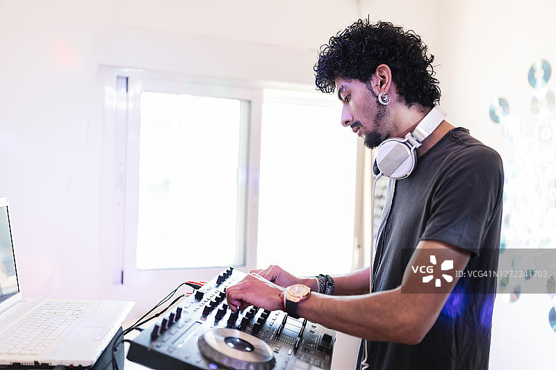 年轻男音乐人在录音室DJ，混合音效图片素材