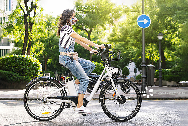 新冠疫情期间在街上骑电动自行车的女人图片素材