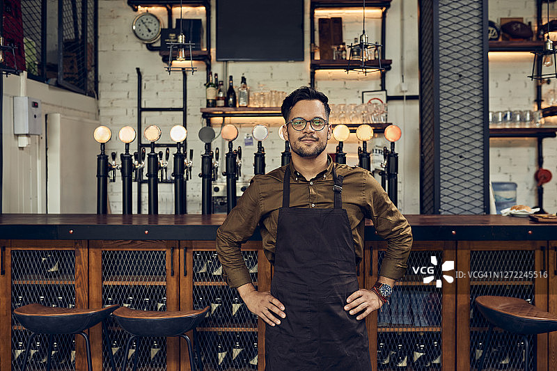 酒吧柜台前自信的侍者肖像图片素材