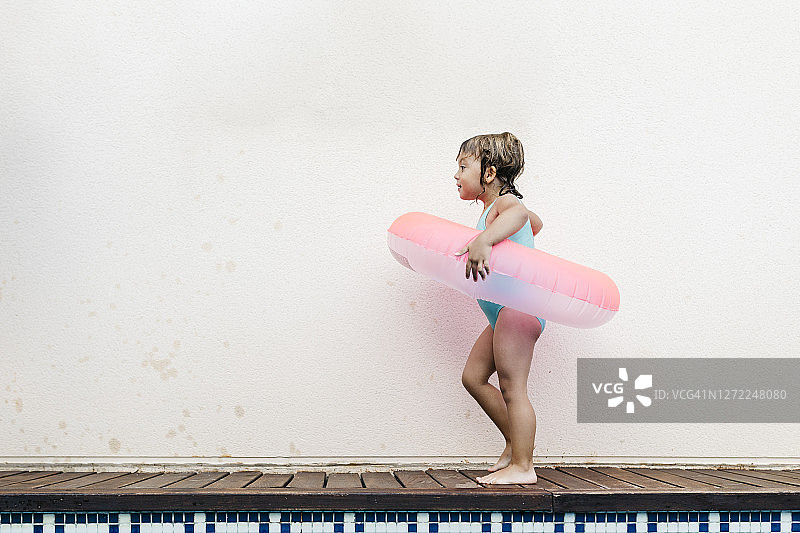 带有游泳圈走在泳池边的小女孩图片素材