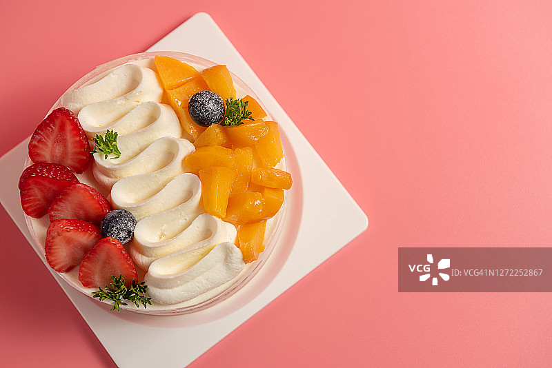 粉色背景上的彩色水果蛋糕图片素材