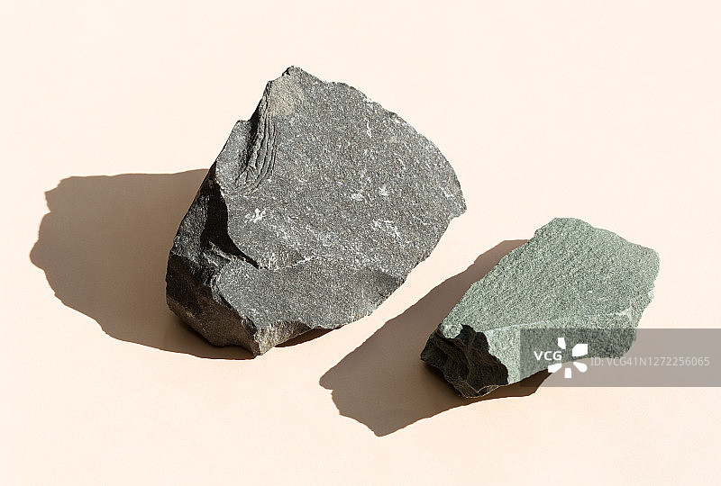 棕色背景上的化妆品或产品石材底座，现代布局展示台，石头集合，俯视角度，硬阴影图片素材