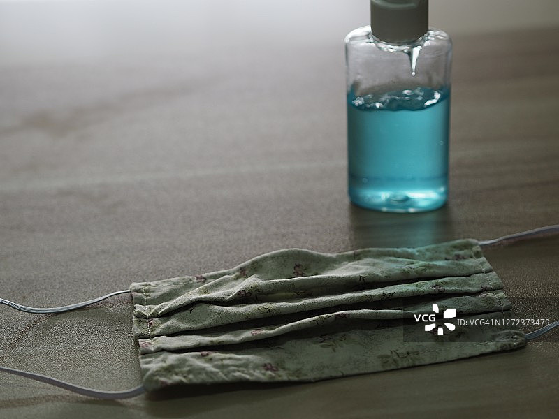 口罩面料和免洗洗手液，置于木桌上，预防新冠病毒等传染病图片素材