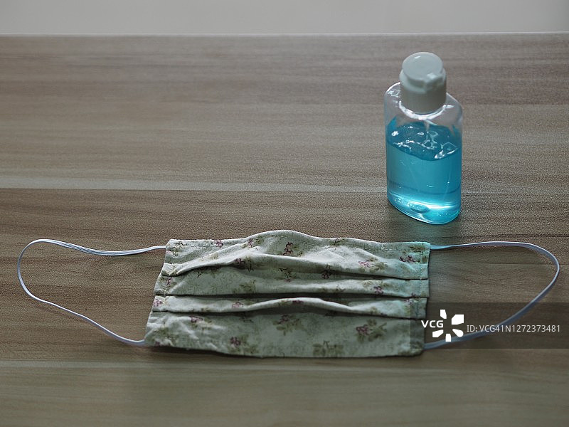 口罩面料和免洗洗手液，置于木桌上，预防新冠病毒等传染病图片素材
