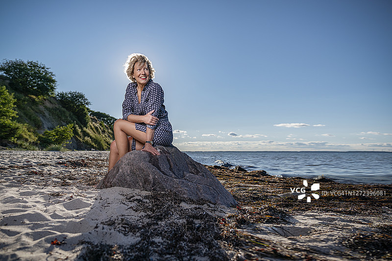 坐在海滩上的有魅力的中年白人妇女图片素材