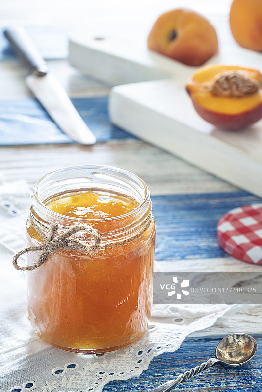 装在玻璃罐中的自制桃子酱与砧板上的桃子图片素材