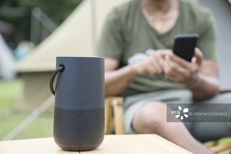 男人使用智能音箱和智能手机图片素材