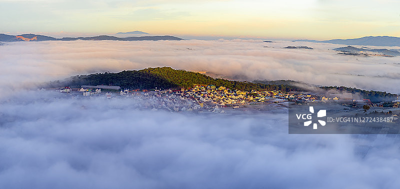 日出时分，云雾在充满魔幻光芒的宁静小村庄中流动图片素材