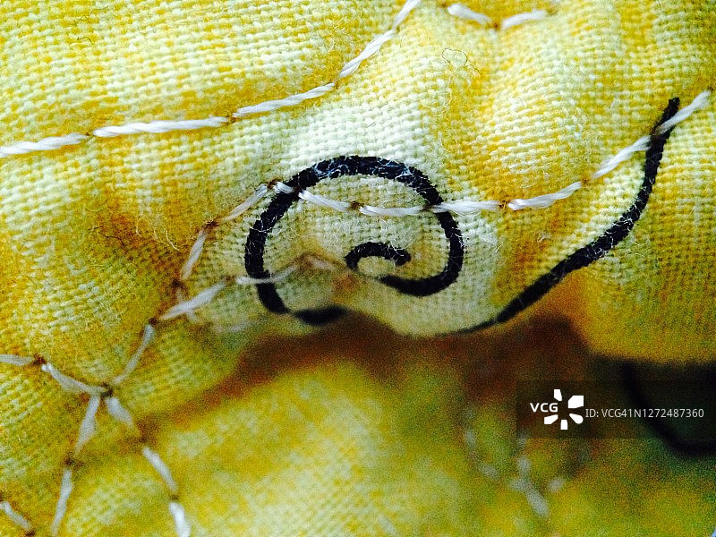 黄色棉布上手工绗缝被子缝线特写图片素材