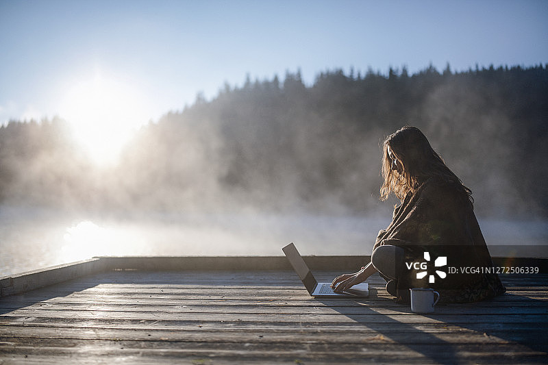 女人在大自然中使用科技产品放松图片素材