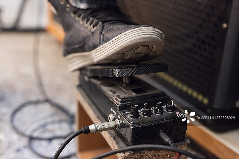 年轻音乐家踩吉他效果器特写图片素材