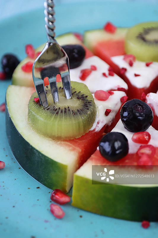 蓝绿色水果披萨特写：酸奶奇异果蓝莓石榴西瓜片图片素材
