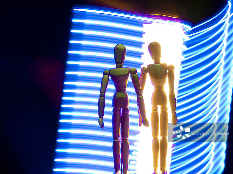 未来场景中两个人体模型代表的一对牵手情侣与太空旅行图片素材