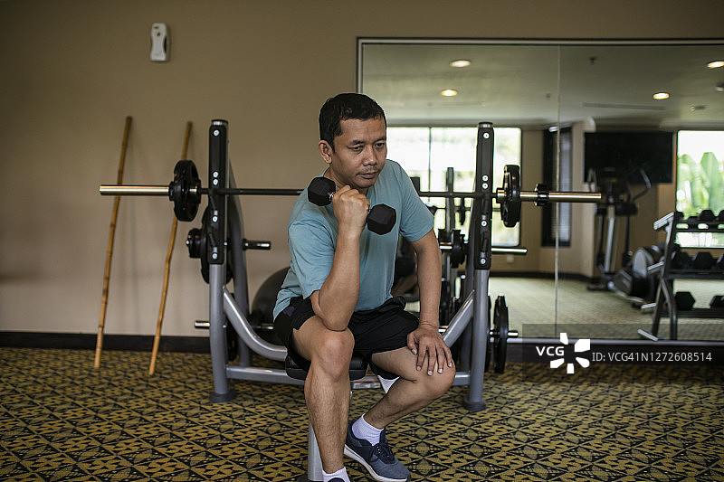 在健身中心做器械锻炼的亚洲男子图片素材