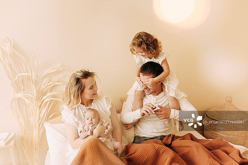 幸福的年轻家庭和两个孩子在舒适的家中休息图片素材