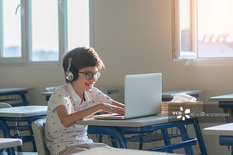 男学生在教室里使用电脑图片素材