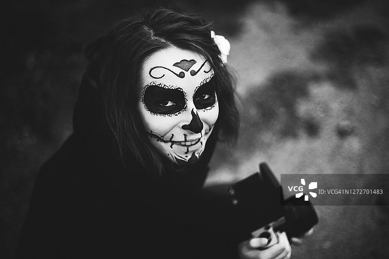 化着精致妆容的年轻女孩拍摄万圣节照片图片素材