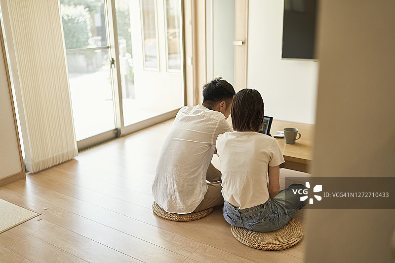 亚洲夫妇在客厅使用平板电脑图片素材