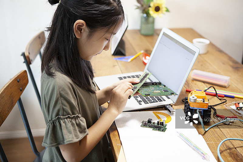 女孩在家制作电子机器人图片素材