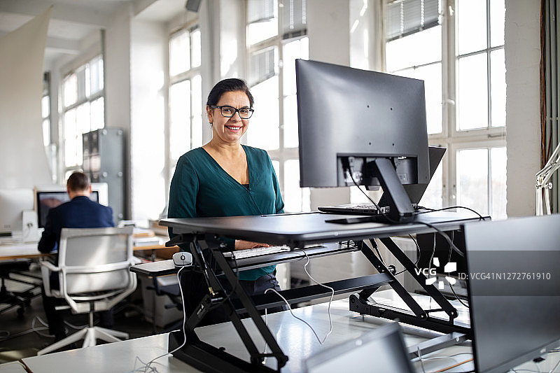 在现代办公室站立办公的女人图片素材