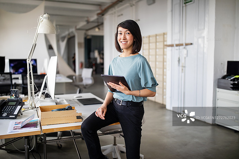 手持平板电脑的自信女商务人士图片素材