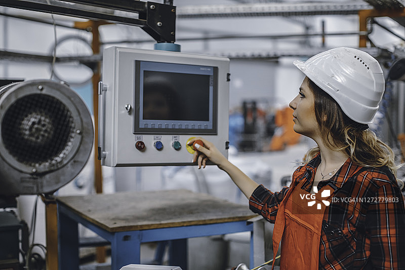 在工厂控制工业面板的年轻女商人肖像图片素材