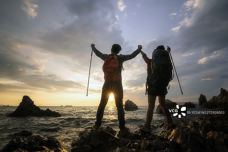 攀登者团队在海岸线附近登山，团队合作成功和领导力概念图片素材