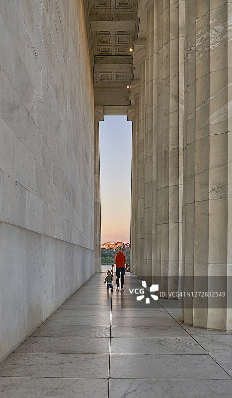 母亲和蹒跚学步的女儿在华盛顿哥伦比亚特区林肯纪念堂观看日出图片素材