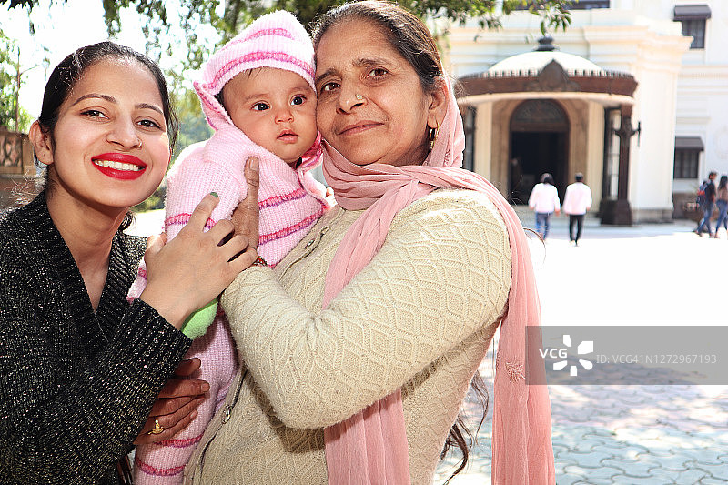 一家人站在印度印多尔的拉尔巴格花园前图片素材