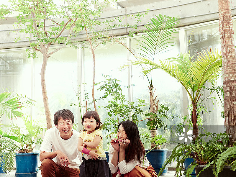 小女孩和父母在绿地里散步图片素材