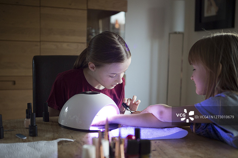 青少年女孩和妹妹在家享受美甲沙龙日图片素材