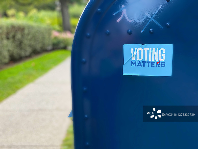 带有投票贴纸的传统蓝色邮政邮箱的侧面轮廓图片素材