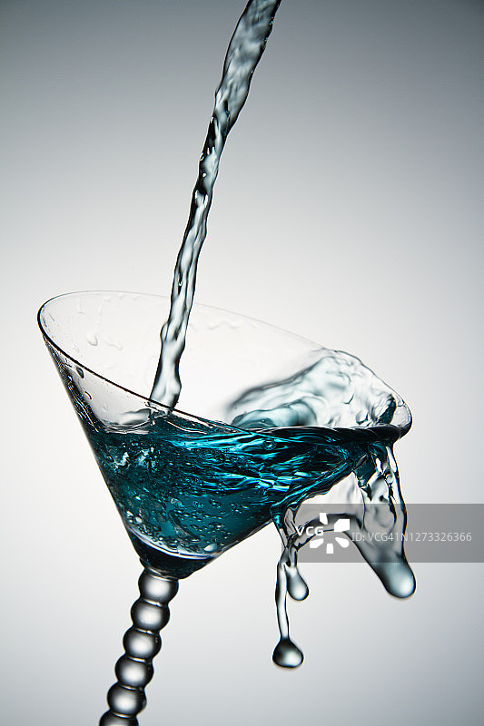 蓝色水花溅落在鸡尾酒杯中图片素材