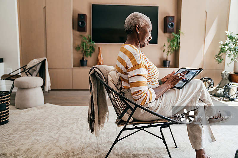 与亲人在线交流的早晨：非裔美国老年妇女对着屏幕微笑图片素材