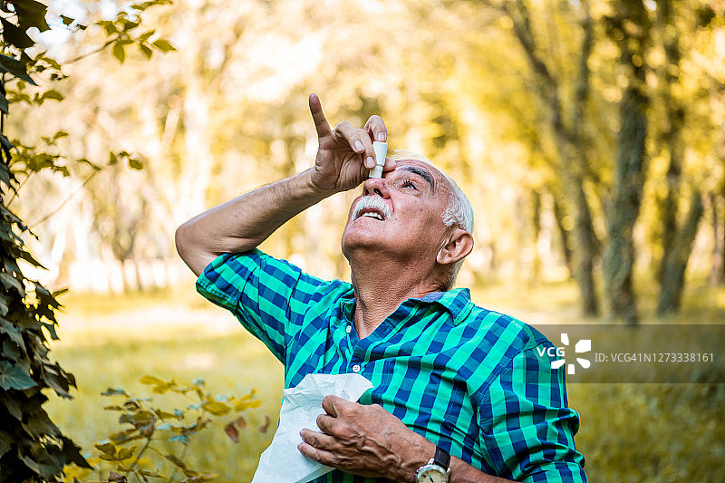 老年男人滴眼药水图片素材