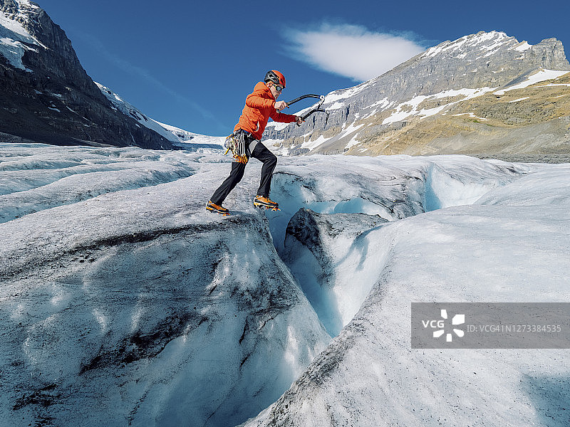 攀冰者在冰川上跨越大型冰隙图片素材
